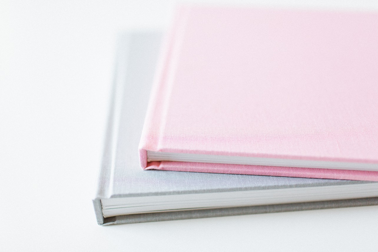 Gray and Pink Linen Photo Album laying on a white table - Portrait Experience