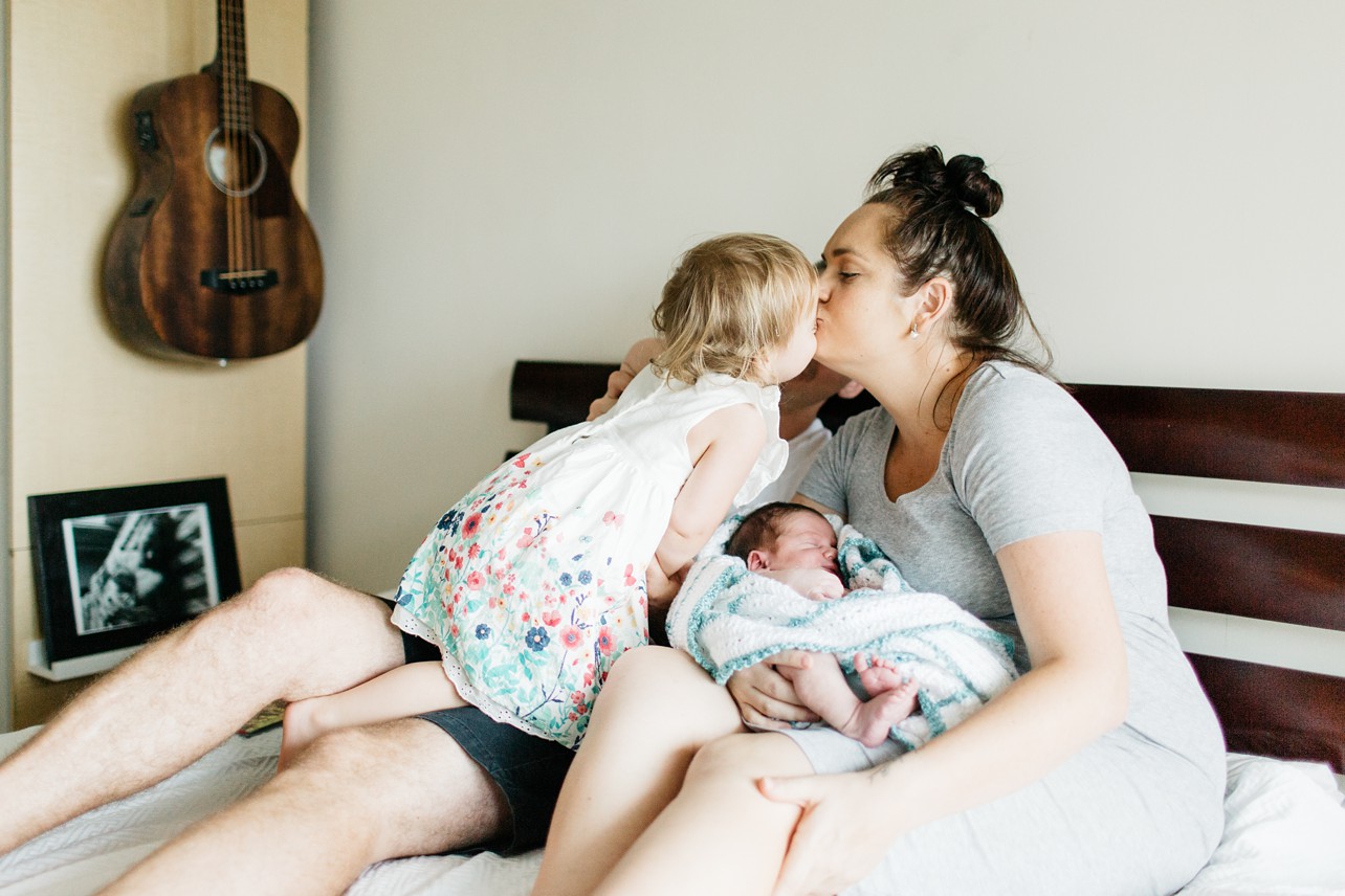 Newborn lifestyle session - a girl and mom are kissing