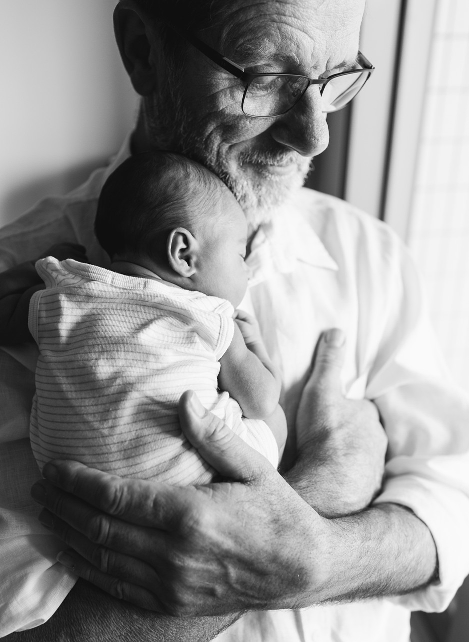 lifestyle newborn photoshoot in Kennedy Town - baby in grandpa's arm in black and white