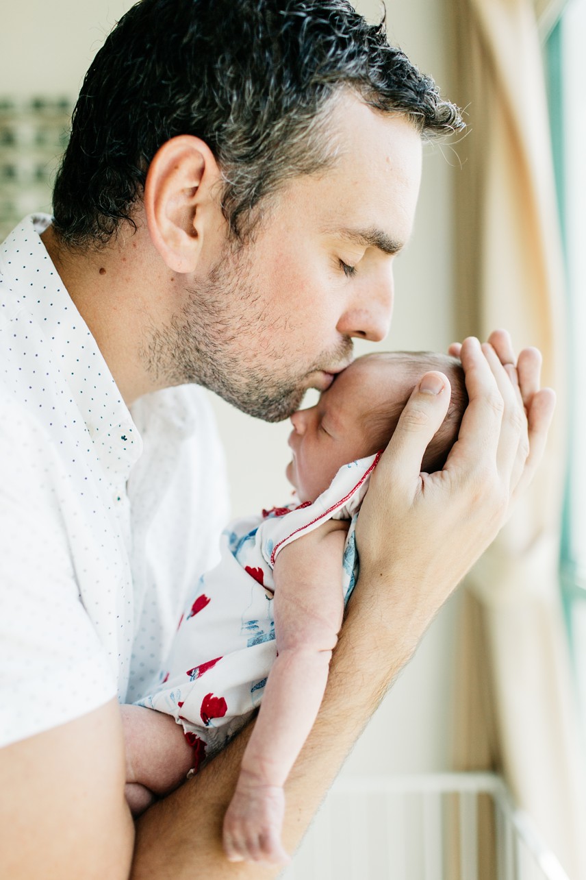 Newborn Home Session in Discovery Bay Hong Kong - dad is kissing a baby by the window