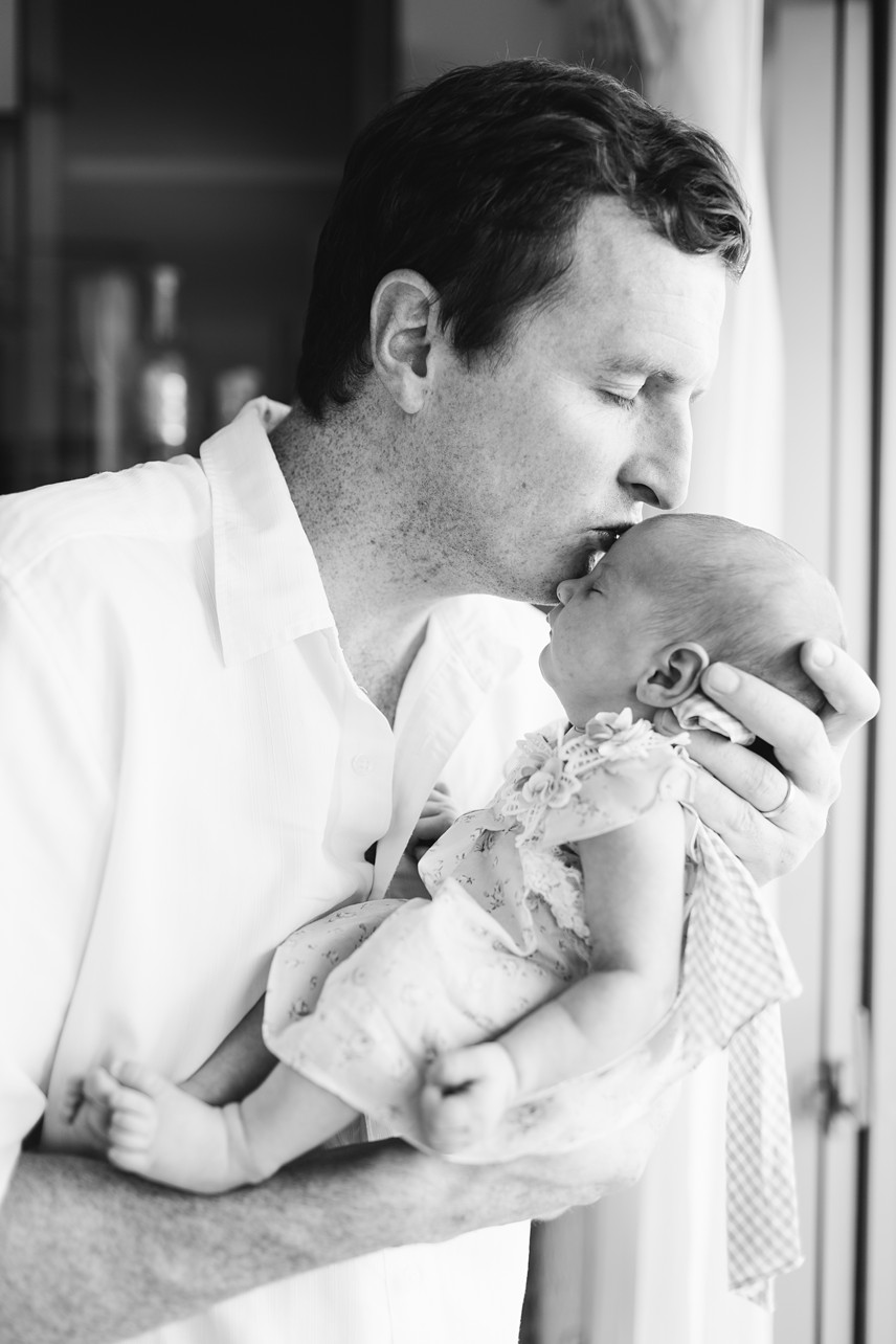 Tung Chung Newborn Session - dad kissing a sleeping baby in black and white