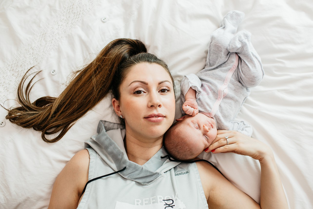 Tung Chung Newborn Session - baby and mom are laying on the bed