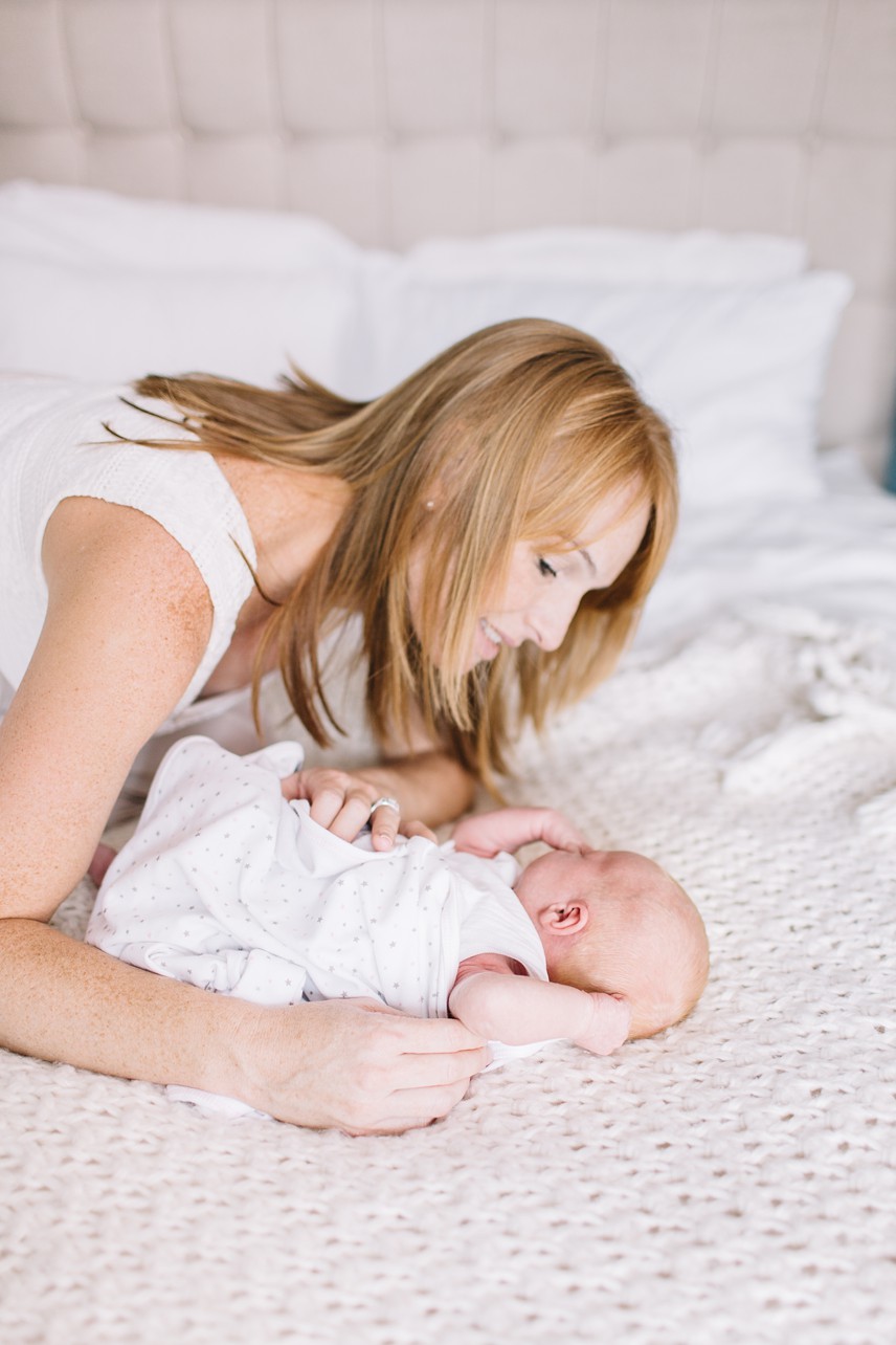 Newborn Photo - mother is talking to her newborn on the bed