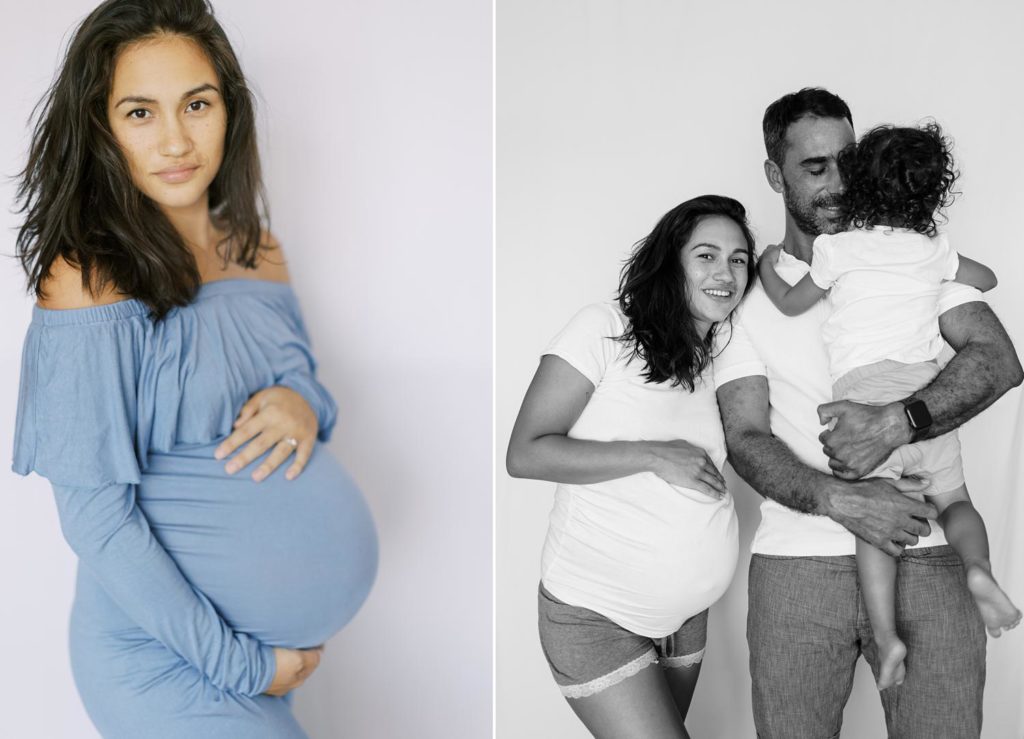 black and white image of family of three in white shirts dad is snuggling his toddler and mom is looking at the camera and pregnant mom in blue dress is posing and looking at the camera