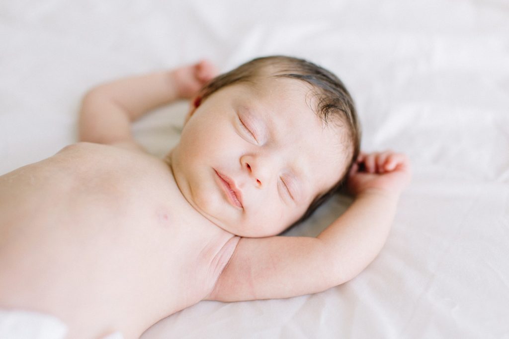 newborn baby is in birth suit - half naked. she is sleeping peacefully