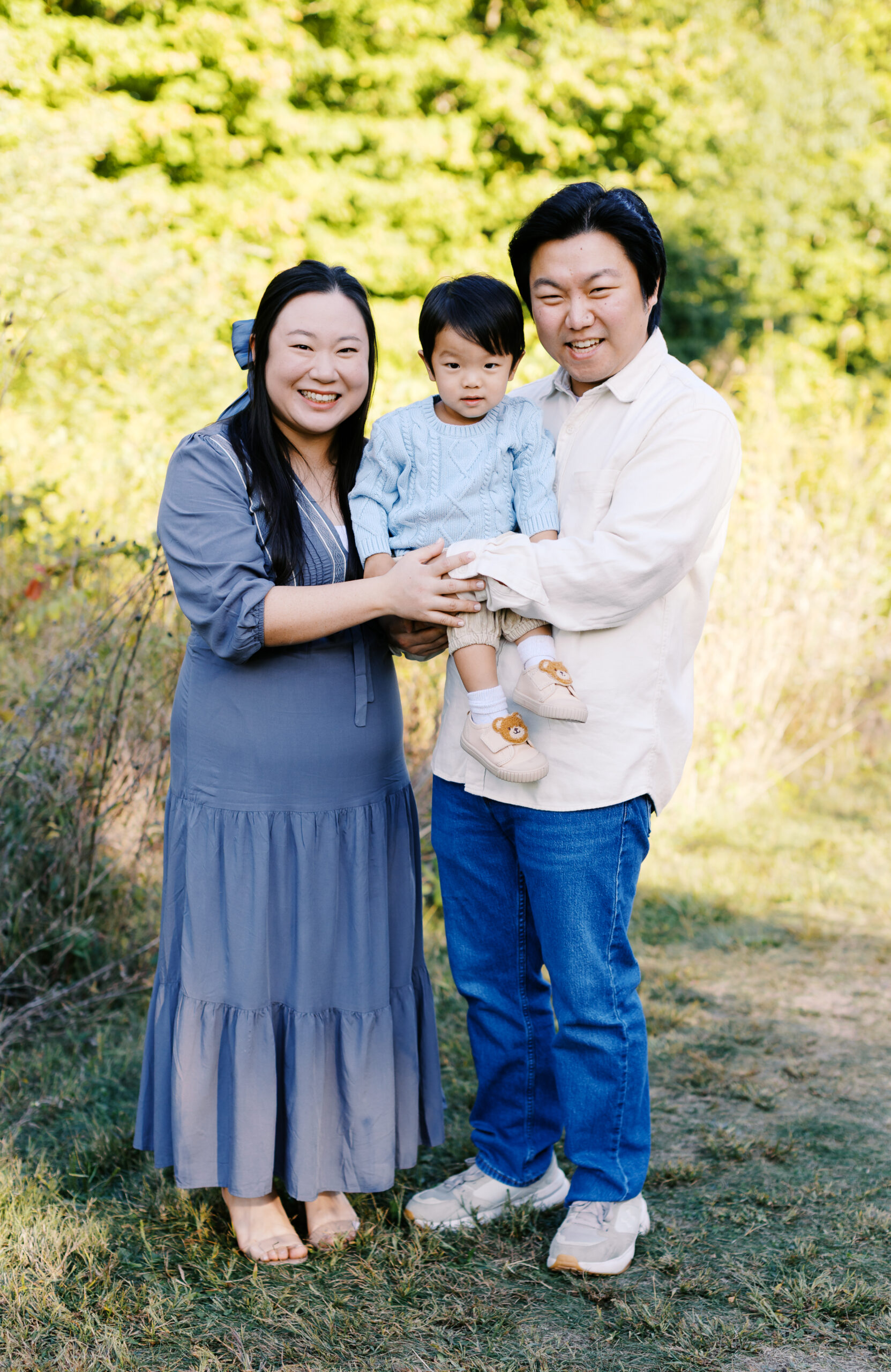 Family of three pose during their family photo at Starkey Park. 