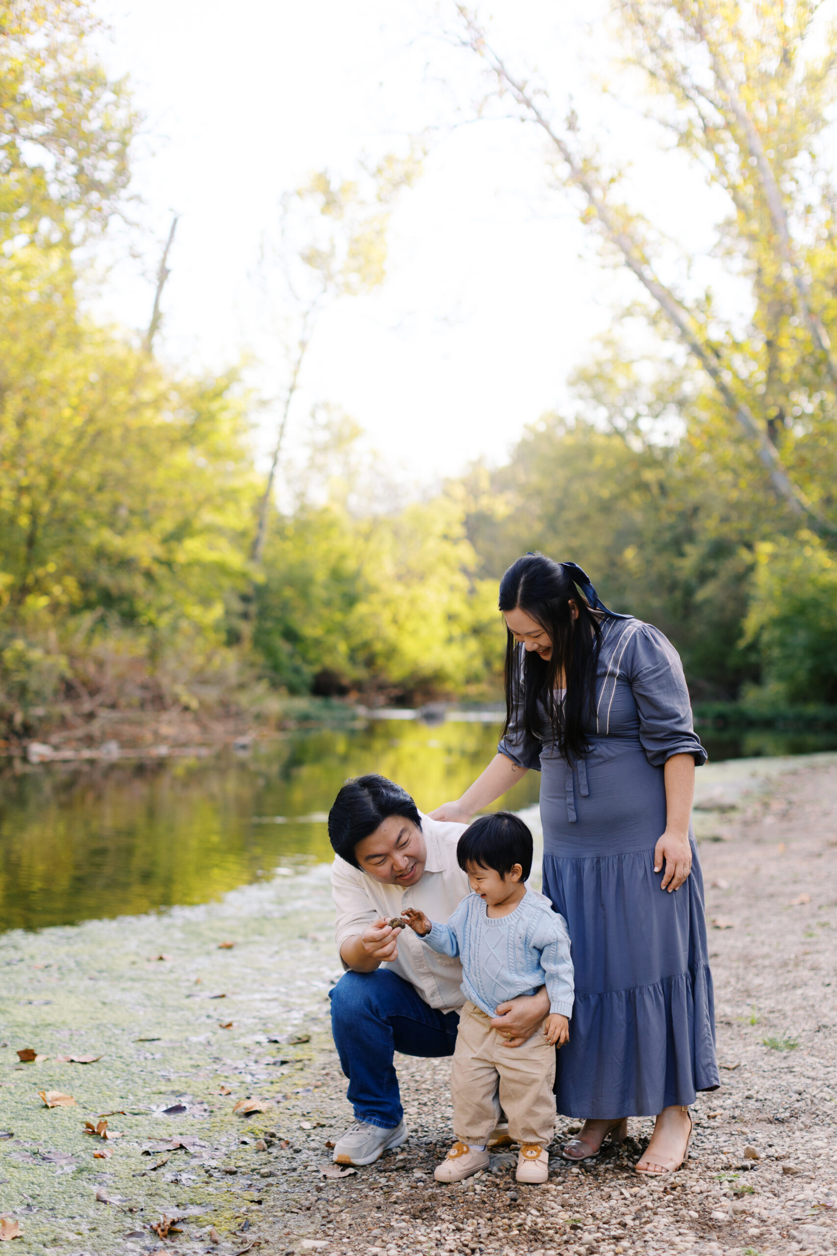 family picking up rocks by a riverbank at Starkey Park